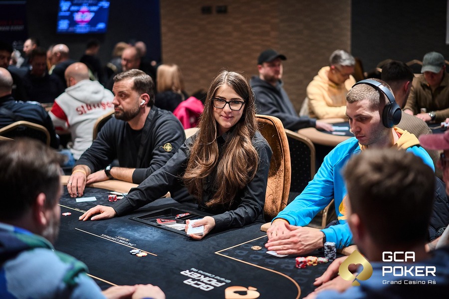 Hráči a&nbsp;dealer u&nbsp;pokerového stolu v&nbsp;živém pokerovém turnaji